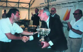 una premiazione in cui il comandante Gianfranco Alberini, per anni Commodoro dello Yacht CLub Costa Smeralda consegna il trofeo a Massimo Magnani.